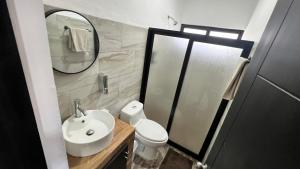a bathroom with a sink and a toilet and a mirror at Casa Braiden in Malucano