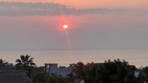 a sunset over the ocean with the sun in the sky at Casa Braiden in Malucano