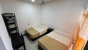 a room with two beds and a ladder at Casa Braiden in Malucano
