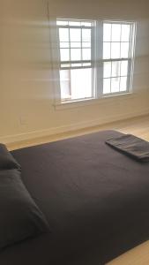 a bedroom with a black bed and two windows at KTown Sanctuary Soul in Los Angeles +7 photos