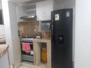 a kitchen with a black refrigerator and a stove at Minidepartamento Centro de Huanuco in Huánuco