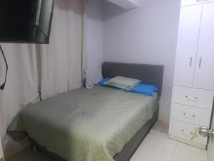 a small bedroom with a bed and a tv at Minidepartamento Centro de Huanuco in Huánuco