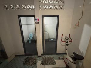 a bathroom with two glass doors and a toilet at Homestay Banua KDP - Coffee & Creative Hub in Jakarta +48 photos