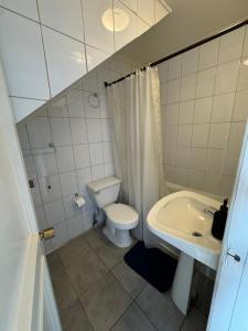 a white bathroom with a toilet and a sink at Cabañas del Puerto in Puerto Montt +62 photos