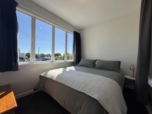 a bedroom with a bed and a large window at Wilmas by the Bay in Riverton