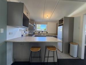 a kitchen with two bar stools and a counter top at Wilmas by the Bay in Riverton