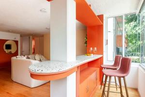an orange and white kitchen with a counter and two stools at Amazing TERRAZO place, 8 guest!! 4 beds in Mexico City +26 photos