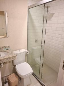 a bathroom with a toilet and a glass shower at Dpto Resort zona aeropuerto in Luque