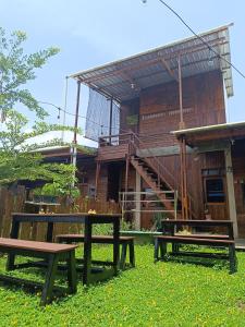 two picnic tables in the grass in front of a building at Rumah Marianne in Sorong
