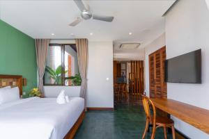 a bedroom with a bed and a desk and a television at Ciao Boutique Danang - New Hotel Opening April 2026 in Danang