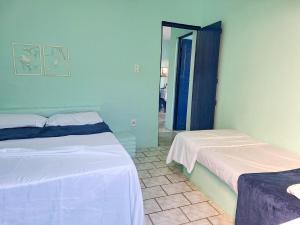 a room with two beds and a mirror at Berlinque Pet Friendly - Muito espaço perto do mar in Vera Cruz de Itaparica