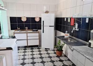 a kitchen with a refrigerator and a sink at Berlinque Pet Friendly - Muito espaço perto do mar in Vera Cruz de Itaparica +20 photos