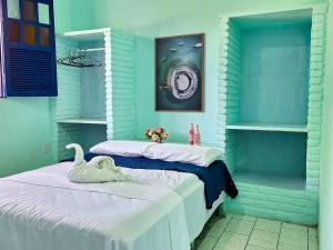 two beds in a room with a swan on them at Berlinque Pet Friendly - Muito espaço perto do mar in Vera Cruz de Itaparica