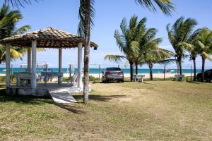 a car parked next to a beach with palm trees at Berlinque Pet Friendly - Muito espaço perto do mar in Vera Cruz de Itaparica