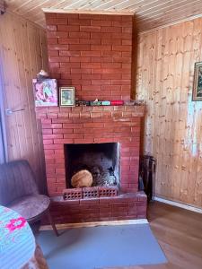 a red brick fireplace in a room with a chair at BibO in Martvili