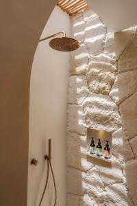 a bathroom with a stone wall and a shower at Bebas Suites - Uluwatu, Bali in Uluwatu +12 photos