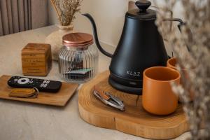 a coffee maker on a wooden cutting board with a cup at Bebas Suites - Uluwatu, Bali in Uluwatu