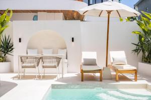 a patio with a table and chairs and an umbrella at Villa Arco Pererenan in Canggu
