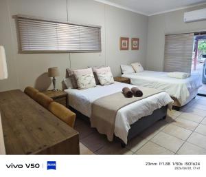 a room with two beds and a couch in it at 4 Houtjies verblyf in Orania