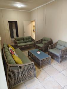 a living room with wicker couches and a table at 4 Houtjies verblyf in Orania