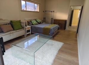 a bedroom with a bed and a glass table at 4 Houtjies verblyf in Orania