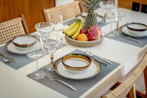 a table with plates and glasses and a bowl of fruit at Villa Arco Pererenan in Canggu