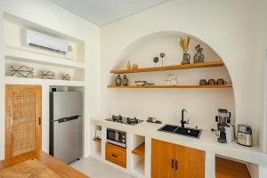 a kitchen with a sink and a refrigerator in a room at Villa Arco Pererenan in Canggu