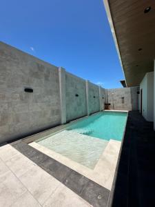 a swimming pool in a building with a stone wall at Roys Suites Galapagos in Puerto Ayora
