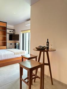 a bedroom with a bed and a table with wine glasses at Roys Suites Galapagos in Puerto Ayora