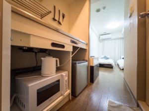 a kitchen with a microwave and a refrigerator in a room at Ichigaya Stay & Wi-Fi 1 in Tokyo