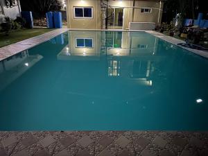 a swimming pool with blue water in front of a house at Group stay Pangasinan in Bugallon