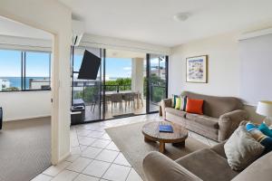 a living room with a couch and a table at Kings Row Apartments in Caloundra