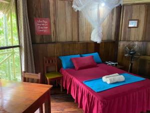 a bedroom with a bed and a table and a table at Amaca Eco Station in Iquitos