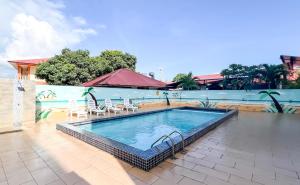 a swimming pool on a patio with chairs at Royal Agate Beach Resort in Pantai Cenang +37 photos