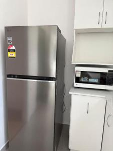 a kitchen with a stainless steel refrigerator and a microwave at The Studio on Barberry with a Pool in Perth