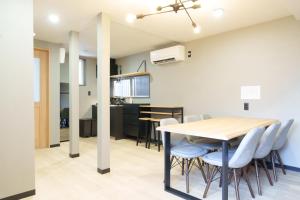 a dining room and kitchen with a table and chairs at 燕のお宿-The Swallow's Inn- in Kumamoto
