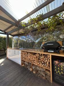 a kitchen with a grill on a wooden deck at Sunbeam Cottage in Havelock North +3 photos