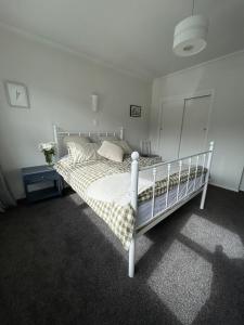 a bedroom with a white bed in a room at Sunbeam Cottage in Havelock North