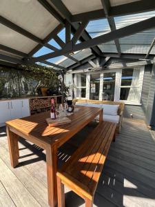 a wooden table and chairs on a wooden deck at Sunbeam Cottage in Havelock North