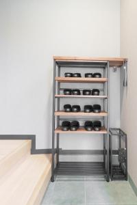 a shelf in a room with a row of shoes at 燕のお宿-The Swallow's Inn- in Kumamoto