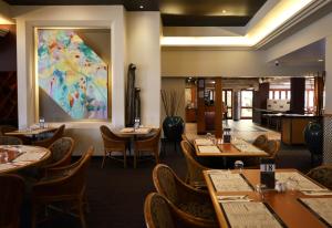 a restaurant with tables and chairs and a painting on the wall at Brisbane International Virginia in Brisbane