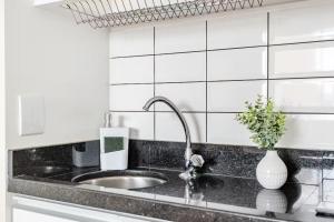 a kitchen with a sink and a vase with a plant at Flat Hotel Vila Olímpia in São Paulo