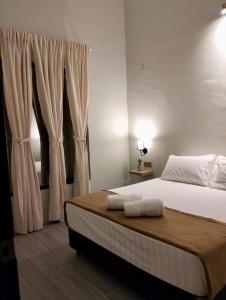 a bedroom with a bed with two towels on it at NitaDinn Guest House in Kampong Ru Sepuloh