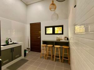 a kitchen with a counter and stools in it at NitaDinn Guest House in Kampong Ru Sepuloh