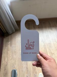 a person holding a white sign in a room at Green Nest Hotel in Hanoi