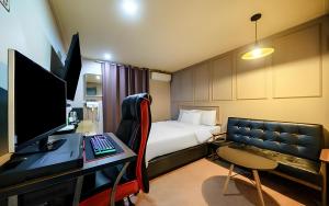 a hotel room with a bed and a desk with a computer at Bucheon The Seollelm Hotel Stay in Bucheon