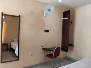 a room with a mirror and a table and a chair at Irene in Kelimutu