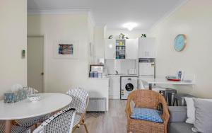 a kitchen and living room with a table and chairs at No 11 The Smugglers Inn in Victor Harbor