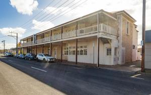 a building with cars parked on the side of a street at No 11 The Smugglers Inn in Victor Harbor