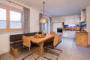 uma cozinha e sala de jantar com uma mesa de madeira e cadeiras em Appartement Nanske em Kaprun